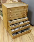 A large collection of fossil specimens, including dinosaur specimens, in an oak and pine chest of