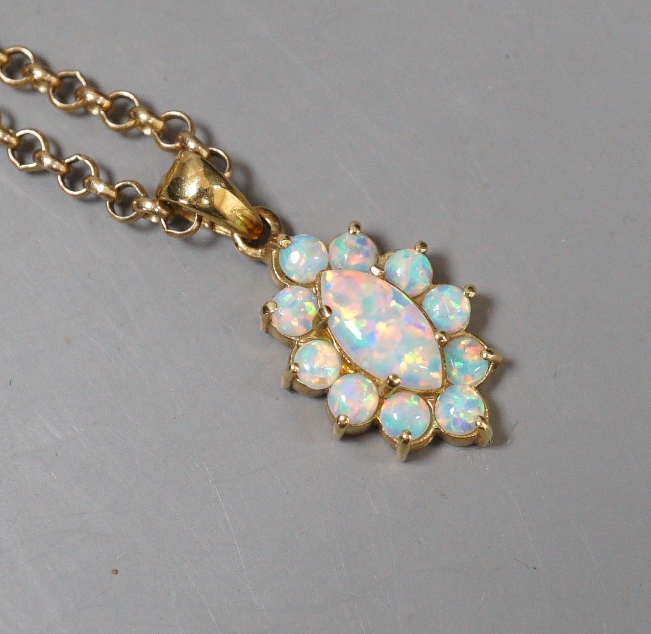 A modern 585 yellow metal and opal set oval cluster pendant, 18mm, on a 9k chain, 50cm, gross weight