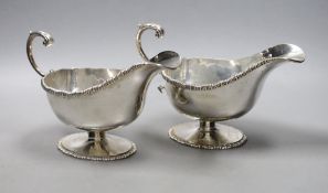 A pair of George V silver pedestal sauceboats with flying scroll handlse, Parker Brothers, Chester
