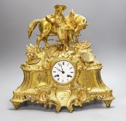 A 19th century French gilt brass mantel clock with man and horse, with key and pendulum, 38cm tall