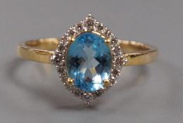 A modern 9k yellow metal, blue topaz and diamond chip set navette shaped cluster ring, size Q, gross