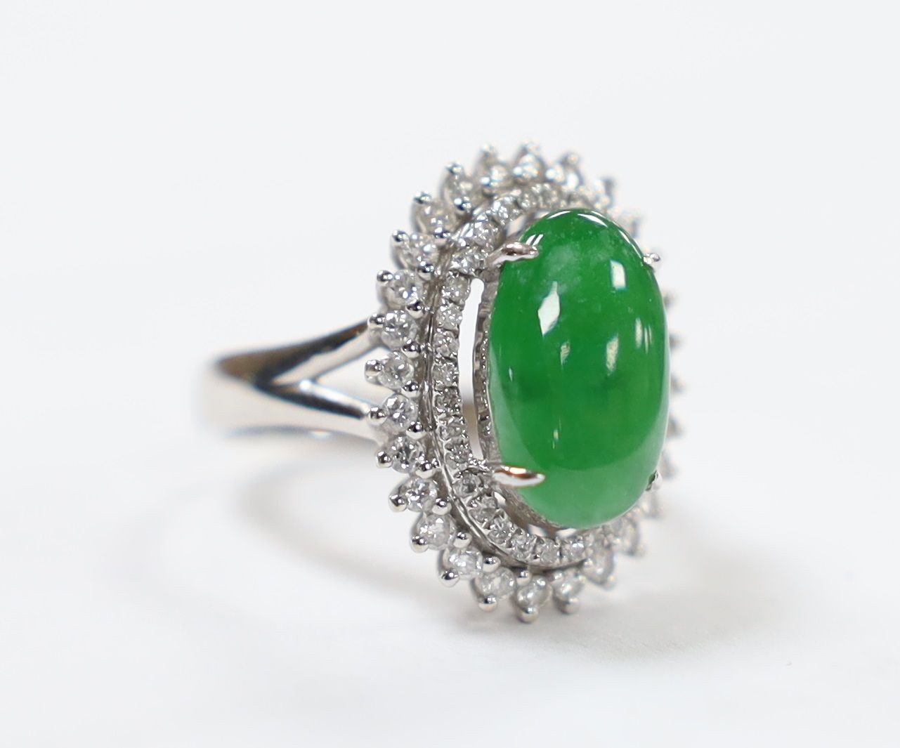 A modern 18k white metal, cabochon jade and two row diamond chip set oval cluster ring size L, gross