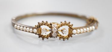 A late Victorian yellow metal, six stone diamond cluster set hinged bangle, with split pearl set