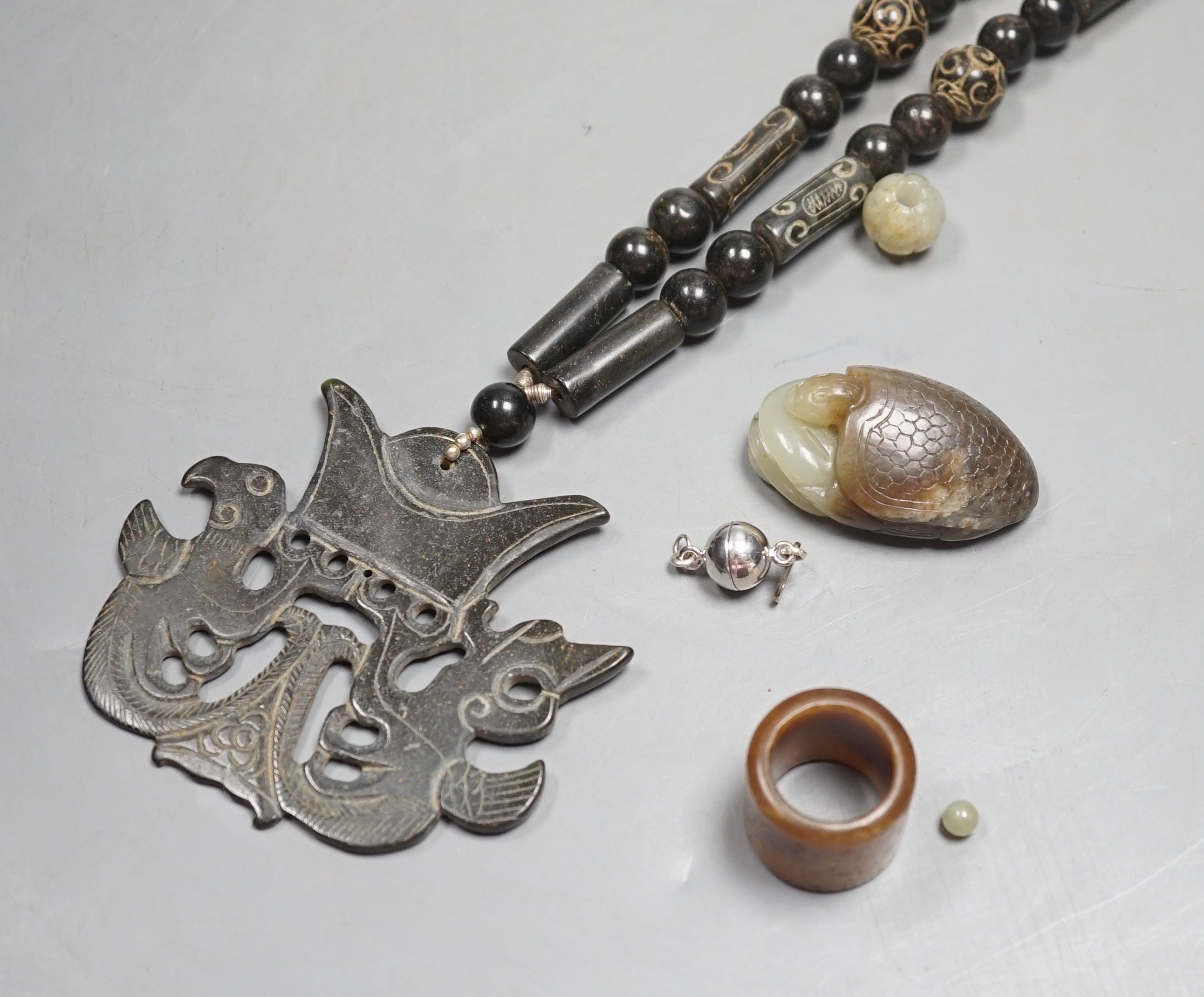 Kai Yin Lo of Hong Kong, a jade turtle and snake pendant, jade archer’s ring and two beads, formerly - Image 2 of 4