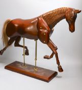 A modern artist's wooden articulated model of a horse, on stand,approx 51 cms wide x 46cms high,