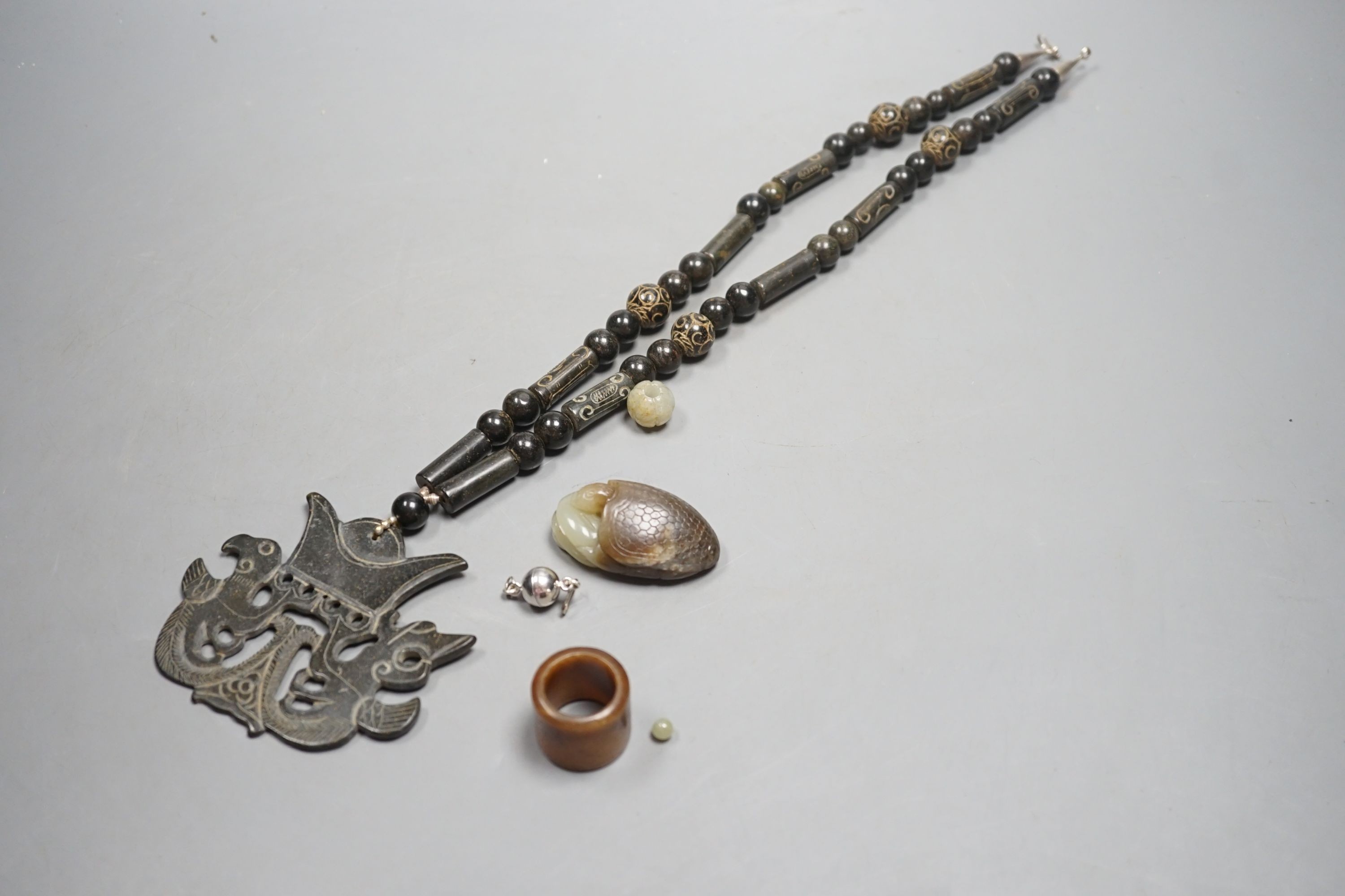 Kai Yin Lo of Hong Kong, a jade turtle and snake pendant, jade archer’s ring and two beads, formerly - Image 3 of 4