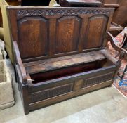 An 18th century carved panelled oak settle (seat in need of repair), width 136cm, depth 46cm, height