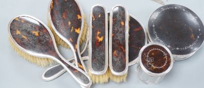 A George V matched silver and tortoiseshell mounted five piece mirror and brush set, a George V