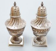 A pair of late Victorian silver vase shaped pedestal pepperettes, by Josiah Williams & Co, London,