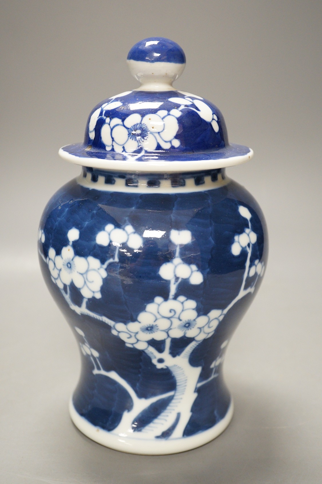 An early 20th century Chinese blue and white prunus vase and cover, 23cm