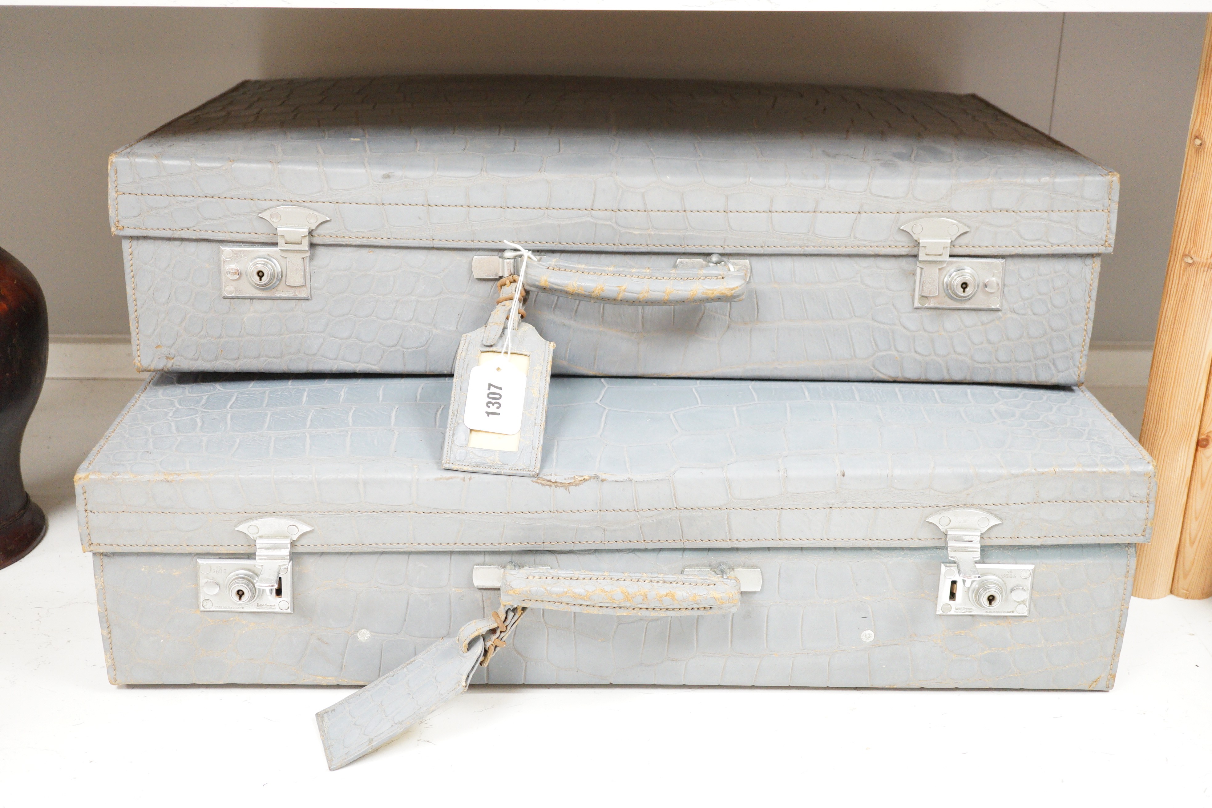 A pair of blue/grey faux crocodile suitcases