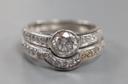 A modern 18ct white gold and collet set single stone diamond ring, with diamond set shoulders and
