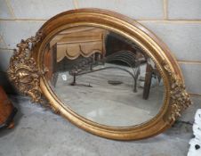 A 19th century French oval giltwood and gesso wall mirror with pierced 'C' scroll and shell