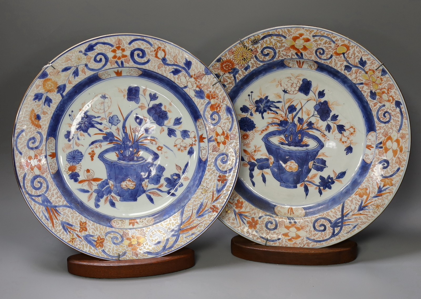 A pair of Chinese Imari dishes, Kangxi period, on wooden stands,31 cms diameter.Provenance - D.C.