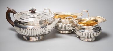 A late Victorian demi-fluted silver circular three piece tea set, Walter & John Barnard, London,
