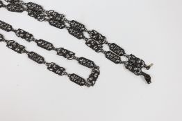 A 19th century Berlin iron work long necklace, with pierced octagonal and scrolling links, the clasp