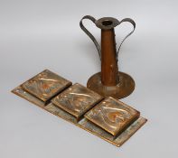 An Arts and Crafts hammered copper candlestick, 18cm tall, and a copper hanging letter rack