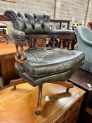 A Victorian style buttoned green leather mahogany swivel desk chair, width 62cm, depth 58cm,