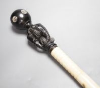 A south East Asian engraved bone and a carved ebony walking cane