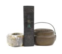A Chinese bronze hand warmer, together with an inscribed inkstick, 16cm wide, and a hardstone