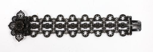 A 19th century Berlin iron work bracelet, with pierced cusped oval links and flower head clasp,