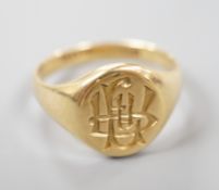 A George V 18ct gold oval signet ring, with intaglio monogram and engraved inscription, size S/T,