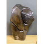 A Zimbabwean carved and polished stone abstract study of a crouching figure, 55cms.