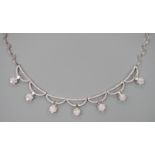 A modern 750 white metal and septuple baguette and round cut diamond cluster set curved link