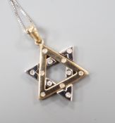 A modern two colour 9ct gold and diamond chip set 'Star of David' pendant, overall 25mm, on a 375