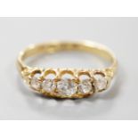 A late Victorian 18ct gold and graduated claw set five stone diamond half hoop ring, size N, gross