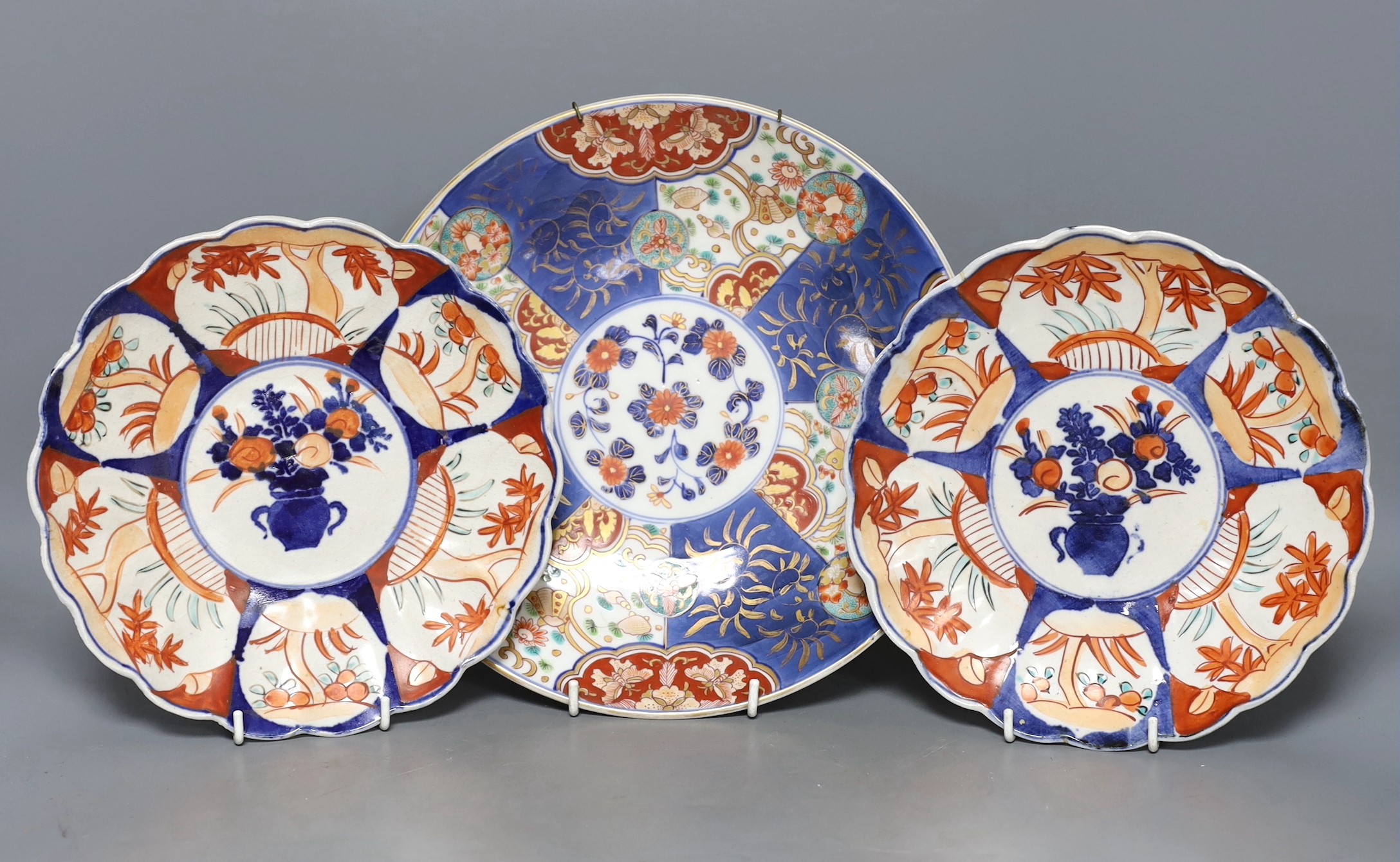 A pair of Japanese Imari plates and similar dish, 27cm