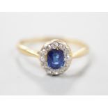 An 18ct, sapphire and diamond set oval cluster ring, size M, gross weight 1.7 grams.