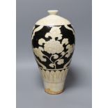 A black and white carved Chinese peony earthenware vase, 34cm tall