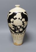 A black and white carved Chinese peony earthenware vase, 34cm tall