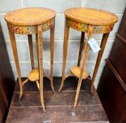 A pair of oval Sheraton style painted satinwood two tier plant stands, width 32cm, depth 26cm,