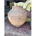 A large Greek style earthenware olive jar on wrought iron stand, height 116cm
