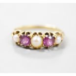 A yellow metal two stone garnet, three stone split pearl set half hoop ring, size K, gross 2.4