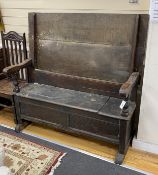 An 18th century oak monk's bench with hinged seat, length 132cm, depth 64cm, height closed 83cm
