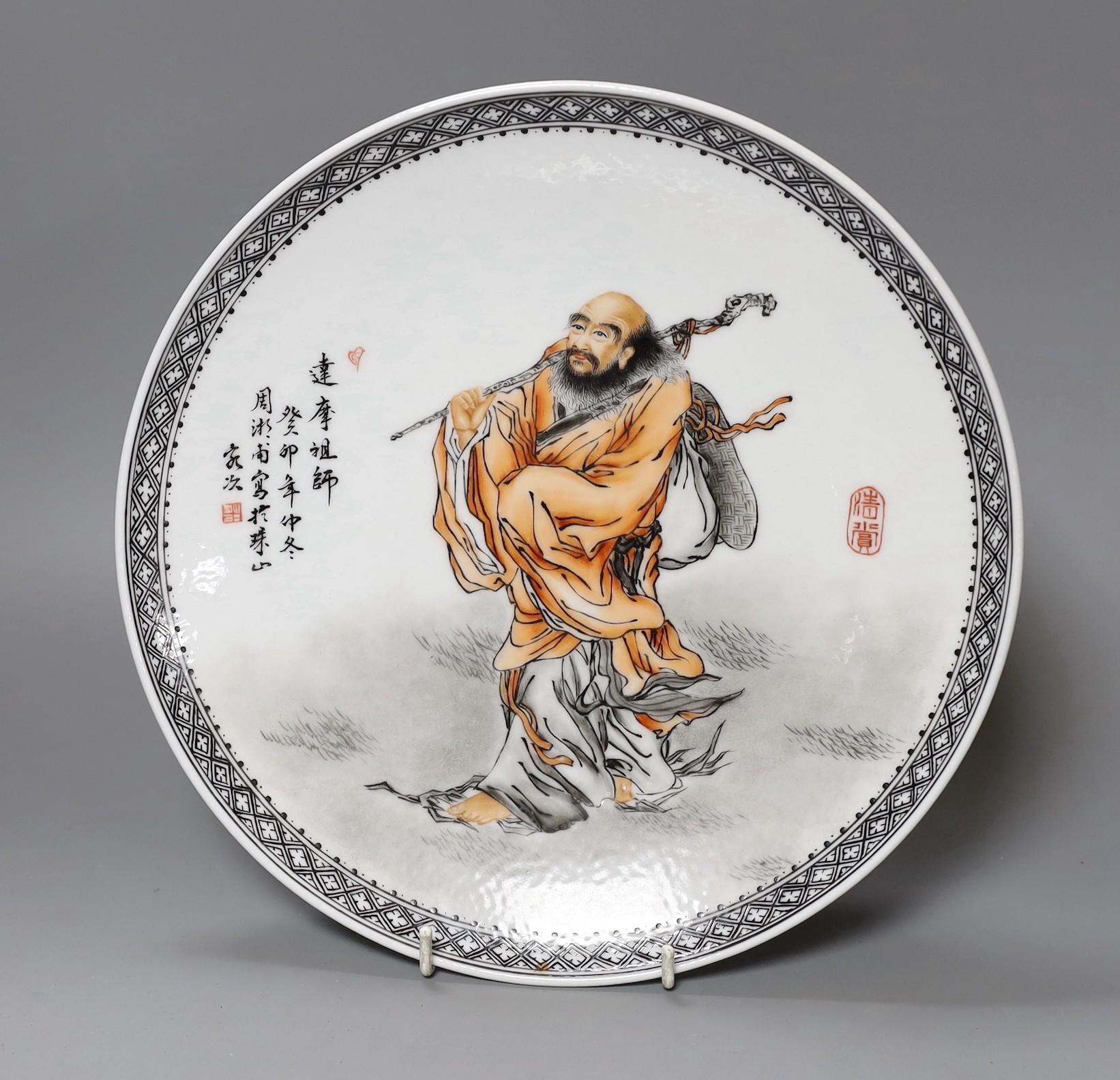 A Chinese famille rose plate of a walking figure with inscription, 28cm diameter