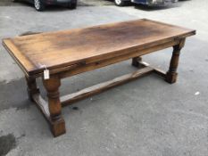 A reproduction 18th century style oak draw leaf refectory dining table with central stretcher,