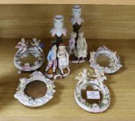 A pair of 19th century continental porcelain figural candlesticks and a group of 4 similar frames