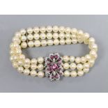 A three strand cultured pearl bracelet with ruby and diamond set 18ct white gold clasp