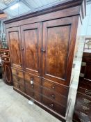 An early Victorian mahogany triple press cupboard, with three panelled doors over an arrangement