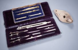 Two cased drawing sets and a Roman oil lamp