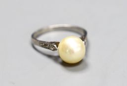 A solitaire cultured pearl set ring, with diamond chip set shoulders, size K