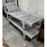A pair of weathered teak garden loungers