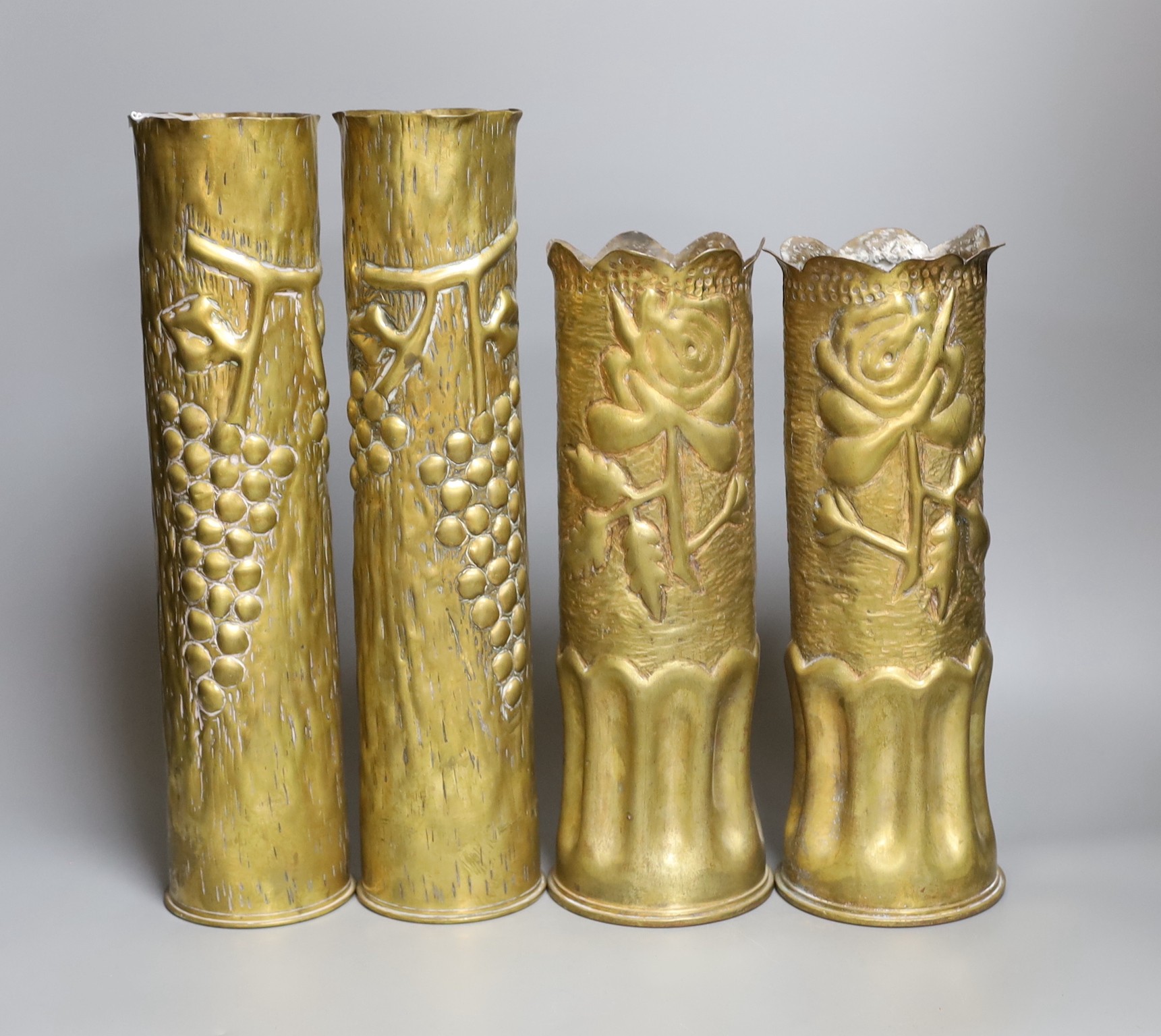 Four decorative carved brass shell cases, tallest 35cm