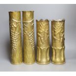 Four decorative carved brass shell cases, tallest 35cm