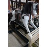 An early 20th century carved wood rocking horse on safety frame (re-painted), height 126cm