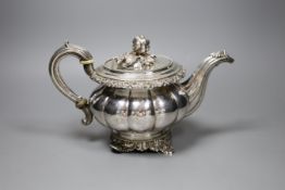 A 19th century Continental white metal teapot, with fruit finial, bone isolators and scroll feet, (